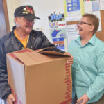 Jim Savage with Post 977 hands Polly Williams of Community Action a box of food on Wednesday.
